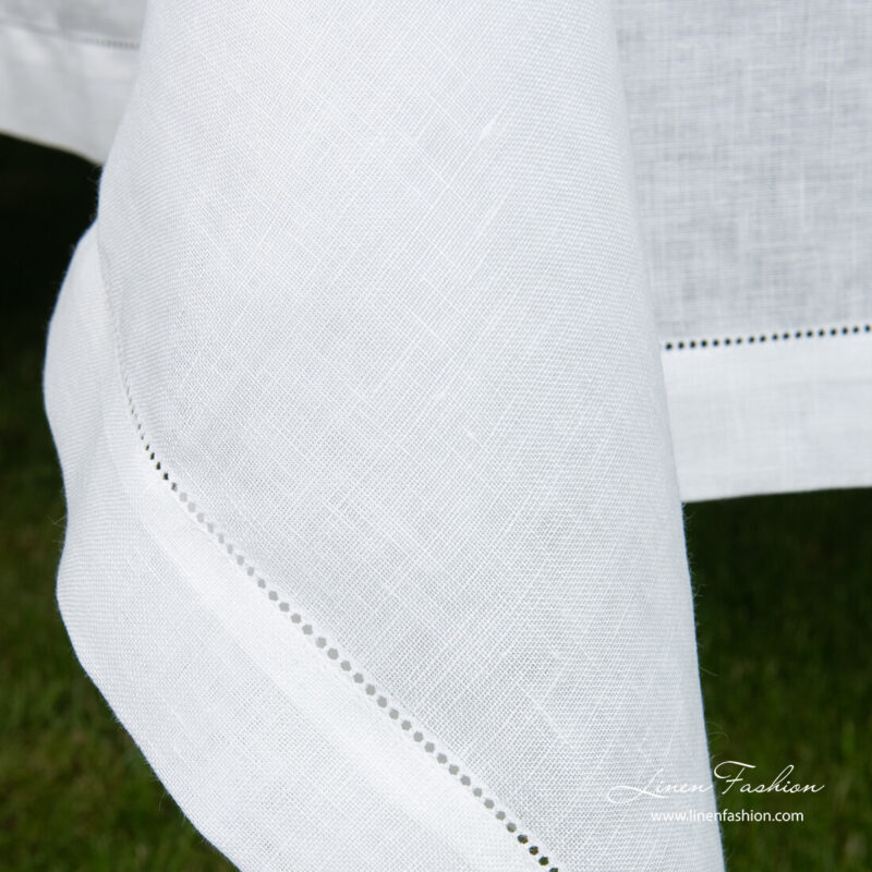 Border of white linen blend tablecloth with hemstitch