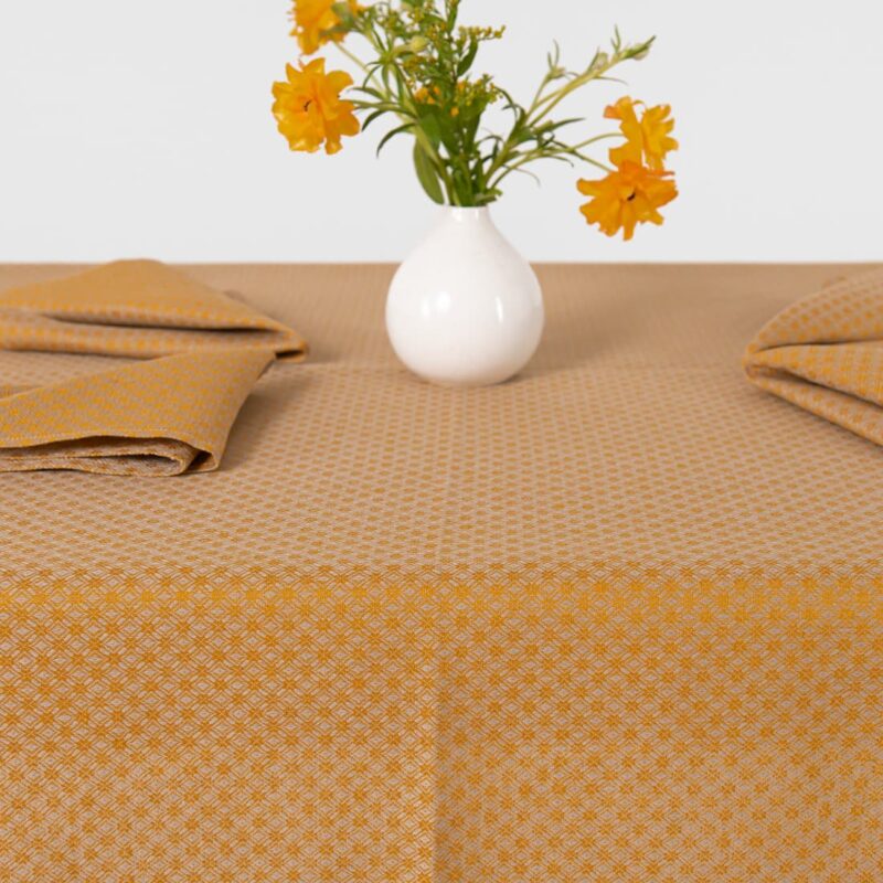 Yellow tablecloth linen cotton, diamond pattern, with flower vase