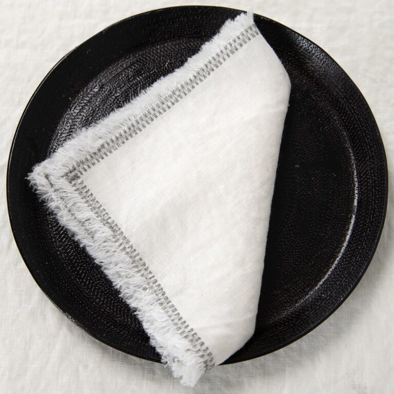 white linen napkin with decorative stitch.